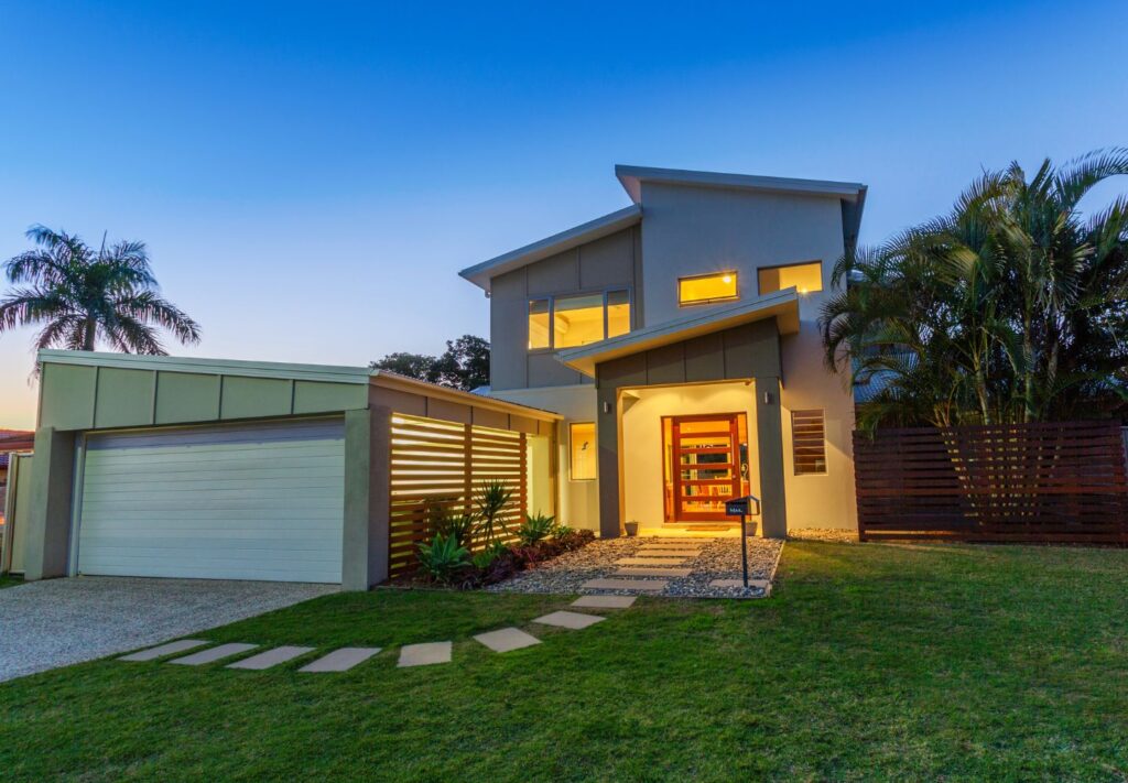 Modern two-story house with garage at twilight.